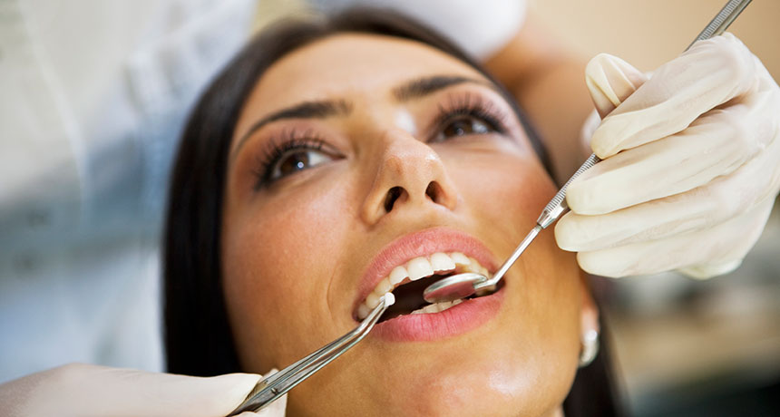 A woman having her teeth checked by the dentist